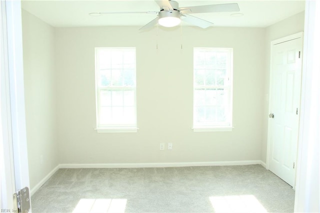 carpeted empty room featuring a wealth of natural light and ceiling fan