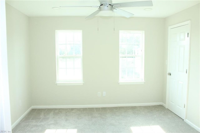 carpeted empty room with a wealth of natural light and ceiling fan