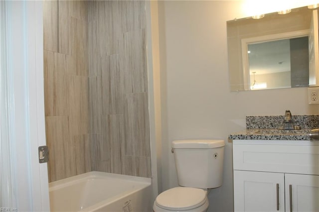 full bathroom with vanity, tiled shower / bath combo, and toilet