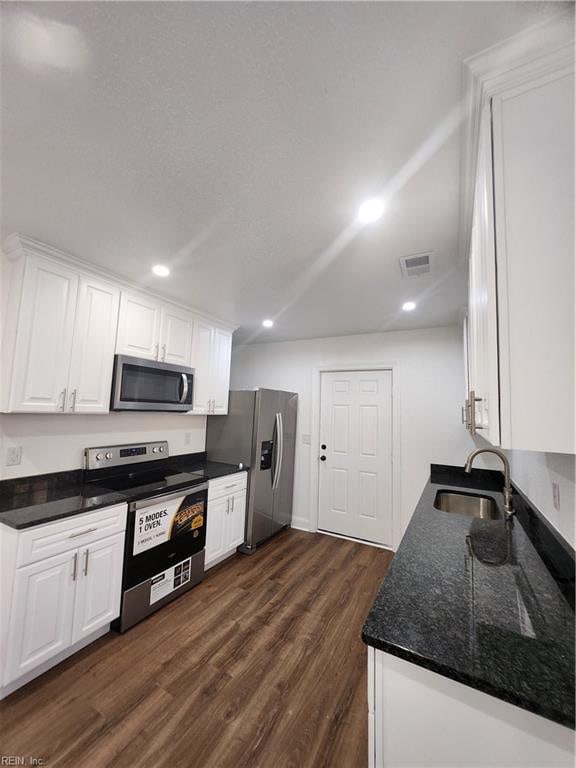 kitchen with sink, dark hardwood / wood-style flooring, white cabinetry, and stainless steel appliances