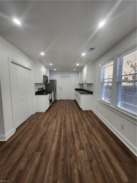 kitchen featuring dark hardwood / wood-style flooring, stainless steel appliances, white cabinetry, and sink