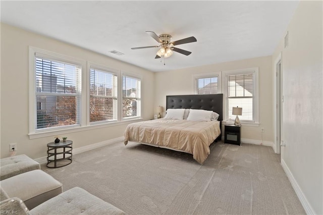 carpeted bedroom featuring multiple windows and ceiling fan