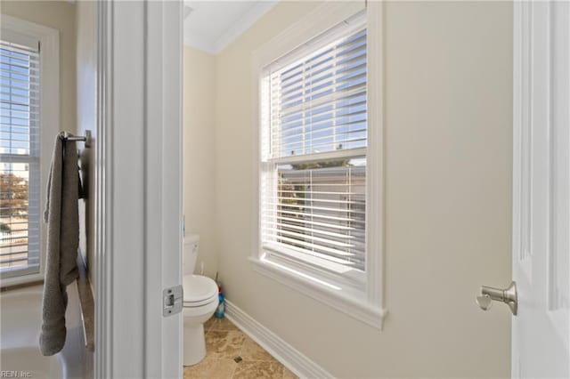 bathroom featuring plenty of natural light, ornamental molding, and toilet