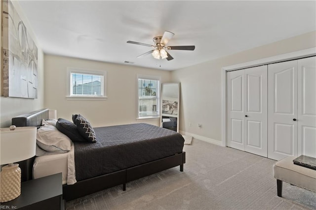 carpeted bedroom featuring ceiling fan and a closet