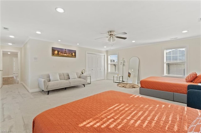 carpeted bedroom with ceiling fan, crown molding, and a closet