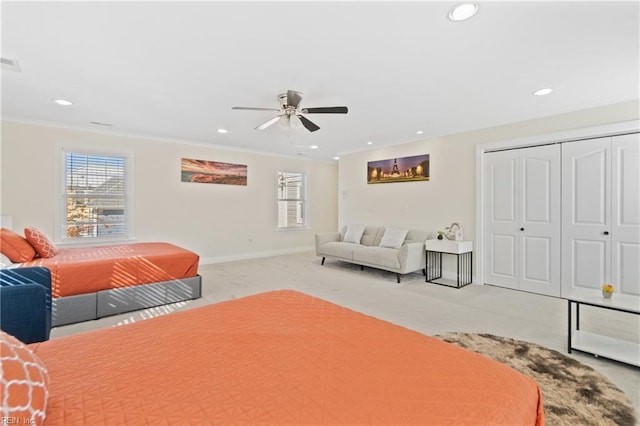 carpeted bedroom with ceiling fan, a closet, and ornamental molding