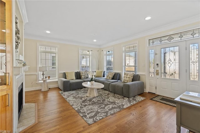 living room with hardwood / wood-style floors, crown molding, and a wealth of natural light