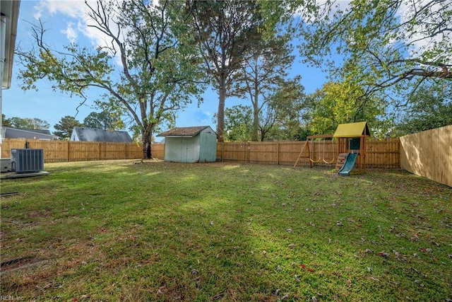 view of yard featuring a storage shed, a playground, and central AC