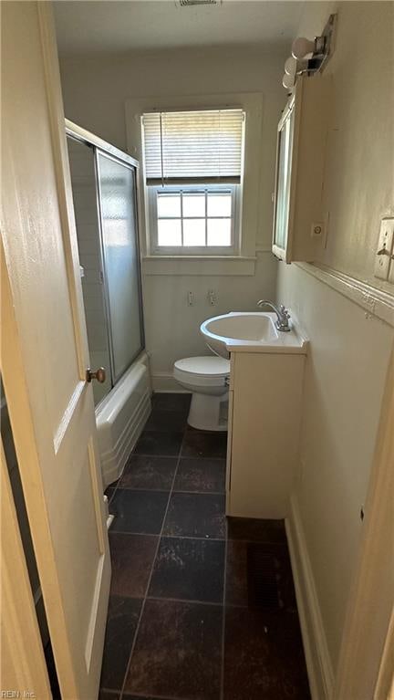 full bathroom with shower / bath combination with glass door, vanity, and toilet