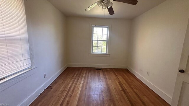 empty room with hardwood / wood-style floors and ceiling fan