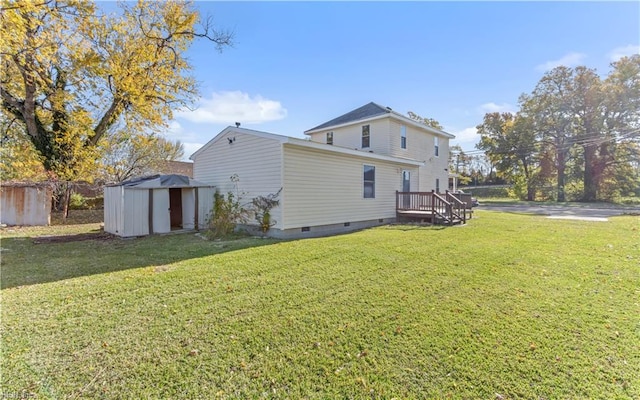 back of house featuring a yard and a storage shed