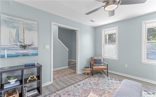 living area featuring hardwood / wood-style floors and ceiling fan