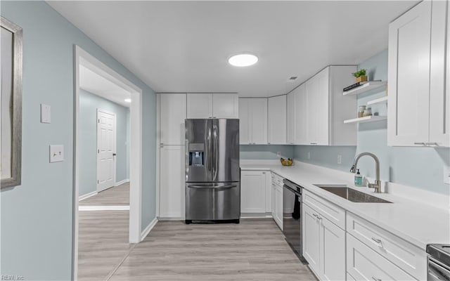 kitchen with white cabinetry, stainless steel appliances, and light hardwood / wood-style floors