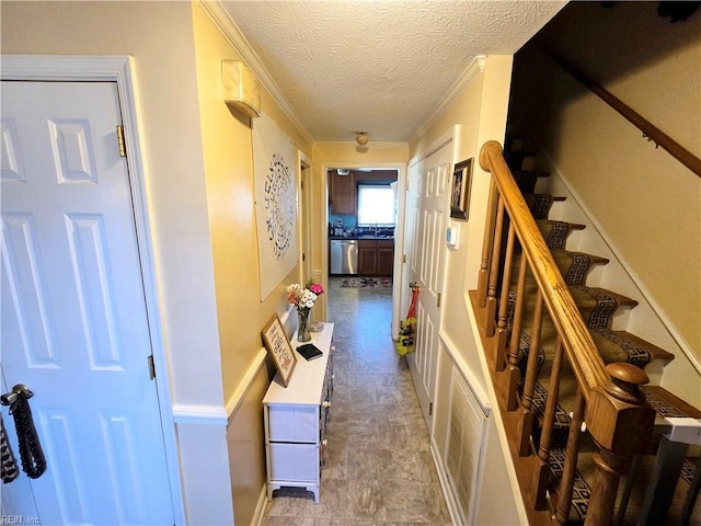 corridor with crown molding, sink, and a textured ceiling