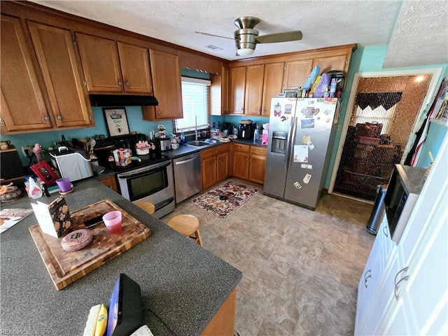 kitchen featuring ceiling fan, sink, a textured ceiling, and appliances with stainless steel finishes