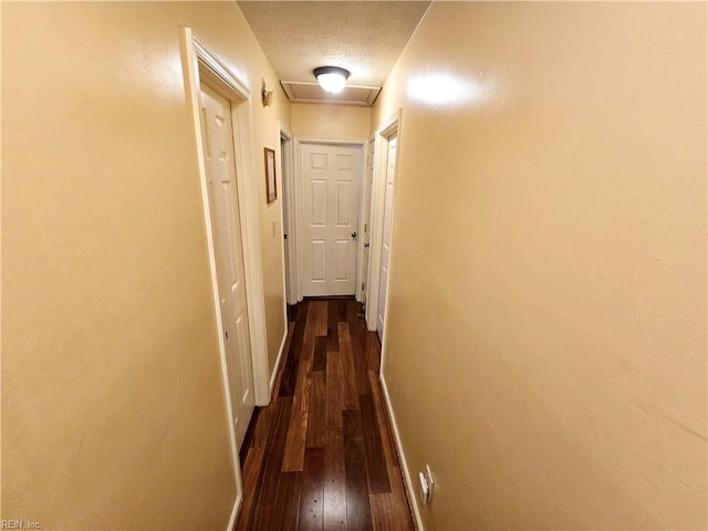 hallway featuring a textured ceiling and dark wood-type flooring