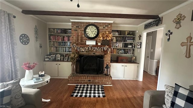 living room featuring built in shelves, a brick fireplace, ornamental molding, and dark wood-type flooring