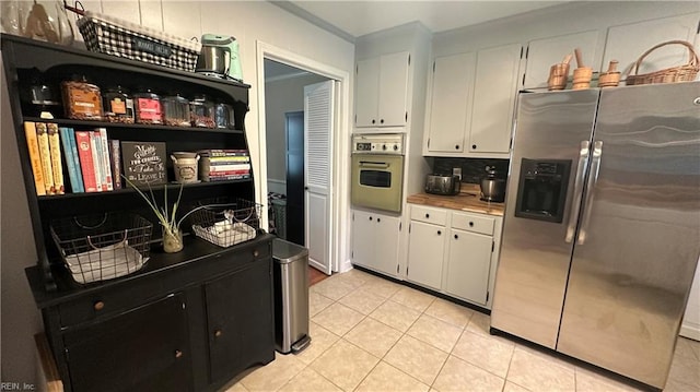 kitchen with stainless steel appliances, white cabinetry, tasteful backsplash, and light tile patterned flooring