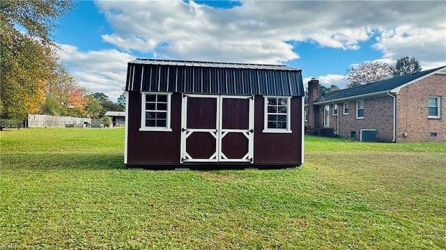 view of outbuilding with a lawn and central AC unit