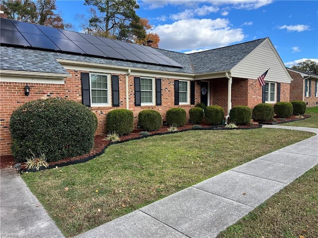 view of front facade with solar panels and a front lawn