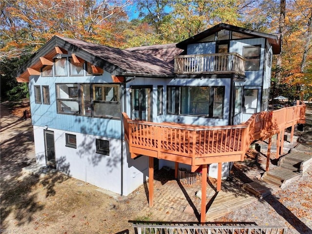 back of property with a balcony and a sunroom