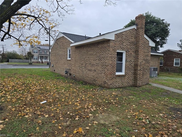 view of side of home featuring central air condition unit and a yard