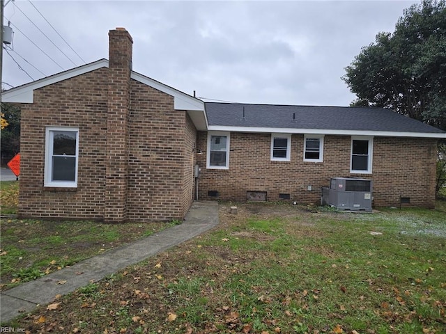 back of house with a lawn and central air condition unit