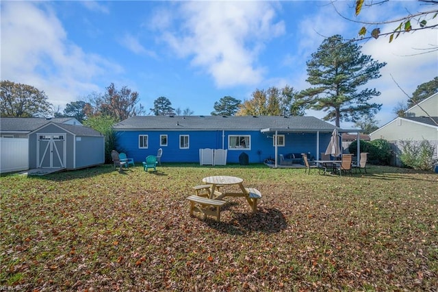 back of house with a shed and a yard