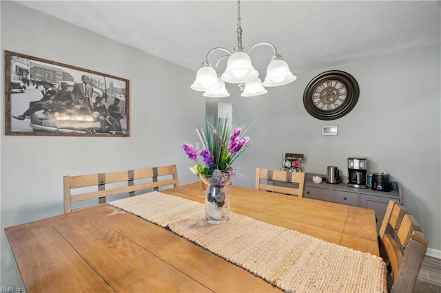 dining room with wood-type flooring and an inviting chandelier