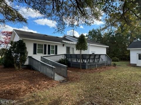 back of property featuring a yard and a deck