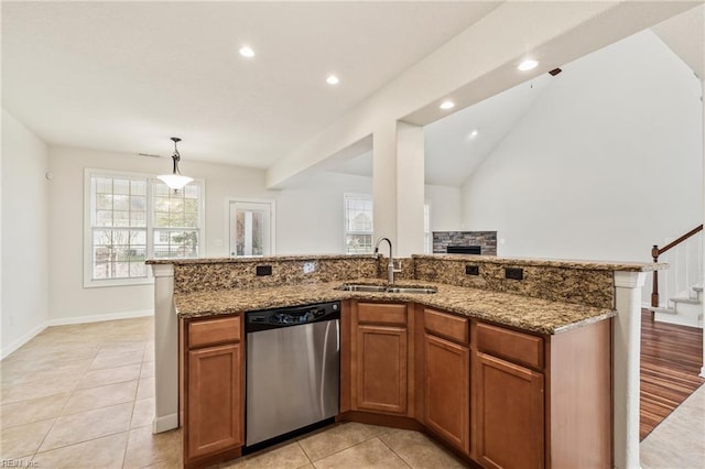 kitchen featuring light stone counters, sink, decorative light fixtures, light hardwood / wood-style flooring, and dishwasher