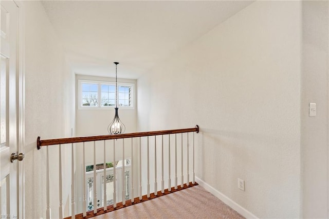 staircase featuring carpet and a notable chandelier