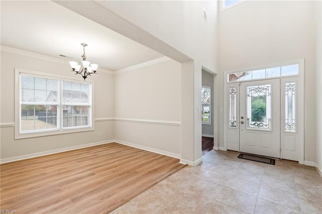 foyer entrance featuring a chandelier, light hardwood / wood-style floors, and ornamental molding