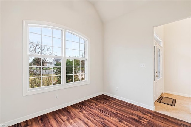 unfurnished room with dark hardwood / wood-style flooring and vaulted ceiling