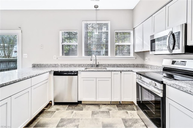 kitchen featuring light stone counters, white cabinetry, sink, and appliances with stainless steel finishes