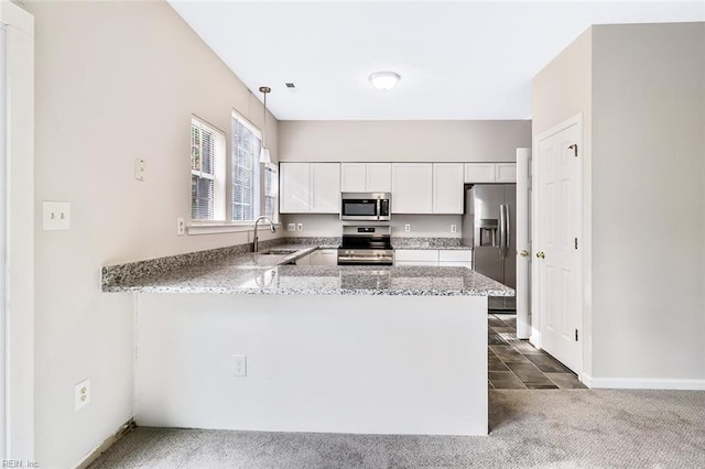 kitchen with kitchen peninsula, white cabinets, stainless steel appliances, and dark carpet