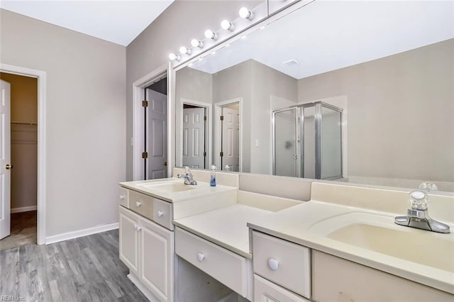 bathroom featuring hardwood / wood-style flooring, vanity, and a shower with shower door