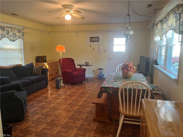 dining area with dark parquet floors and ceiling fan