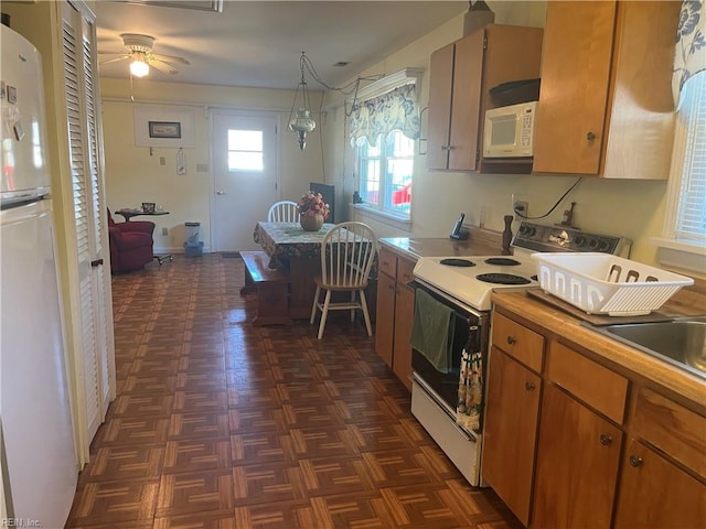 kitchen with dark parquet flooring, white appliances, and ceiling fan