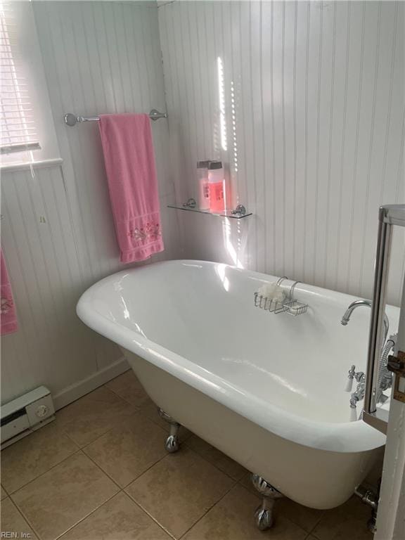 bathroom featuring a washtub, a baseboard radiator, and tile patterned flooring