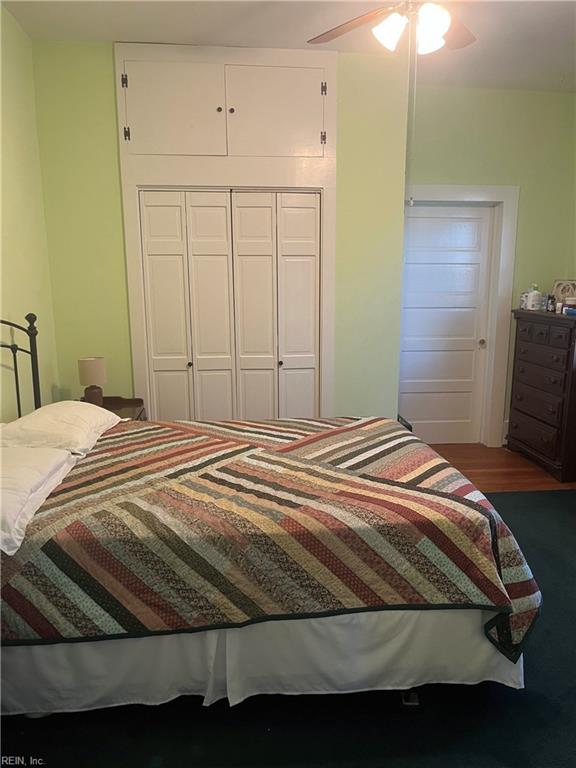 bedroom with hardwood / wood-style floors, ceiling fan, and a closet