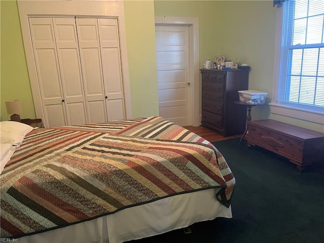 bedroom featuring a closet and dark colored carpet