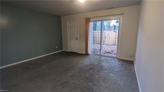 spare room with dark colored carpet