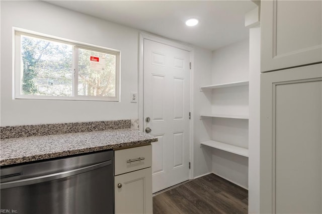 kitchen with stainless steel dishwasher, dark hardwood / wood-style flooring, light stone counters, and white cabinets