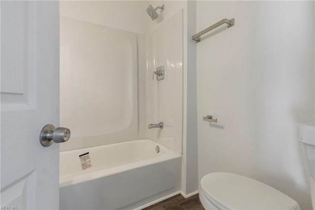 bathroom with hardwood / wood-style floors,  shower combination, and toilet