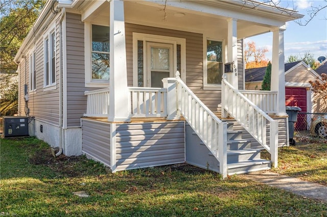 view of exterior entry with a yard and a porch