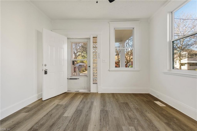 empty room with dark hardwood / wood-style floors and ornamental molding