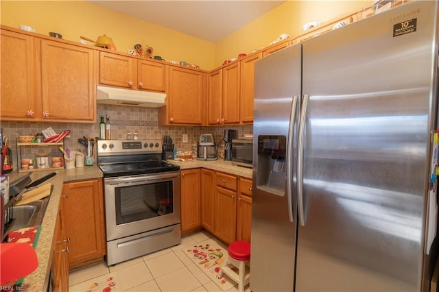 kitchen featuring decorative backsplash, appliances with stainless steel finishes, light tile patterned floors, and sink