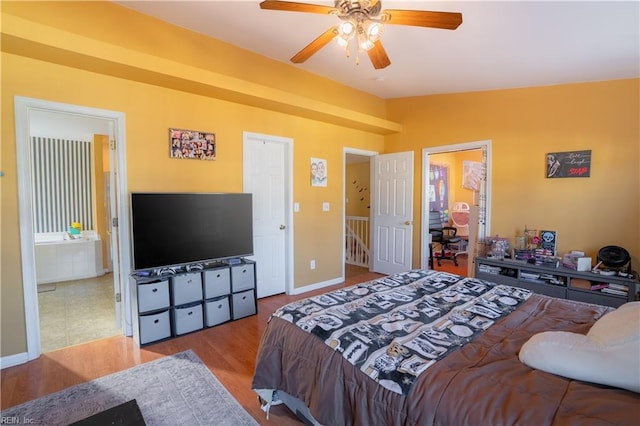 bedroom with ensuite bathroom, ceiling fan, light wood-type flooring, and lofted ceiling