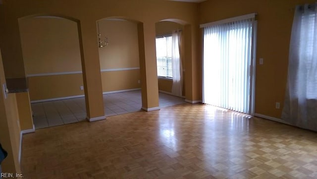 empty room featuring a chandelier and light parquet flooring